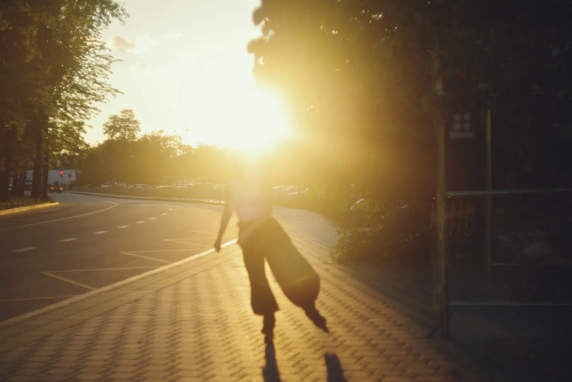 Woman walking through a city street at golden hour, a picture of everyday living
